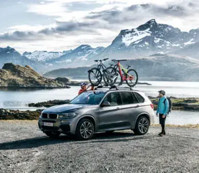 Freizeitbedarf Bergige Landschaft mit einem Auto am Ufer und einer Person daneben