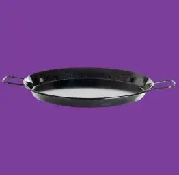 Eine Paella Pfanne vor einem lila Hintergrund
