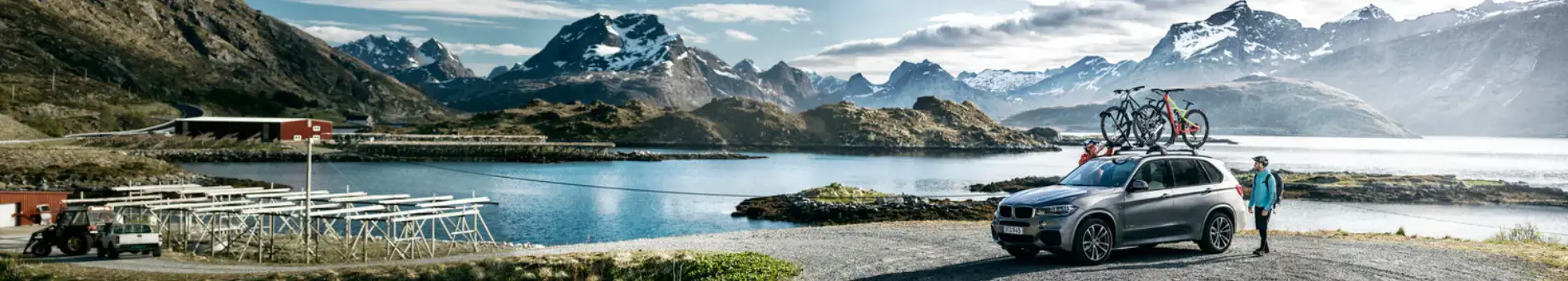 Freizeitbedarf Bergige Landschaft mit einem Auto am Ufer und einer Person daneben